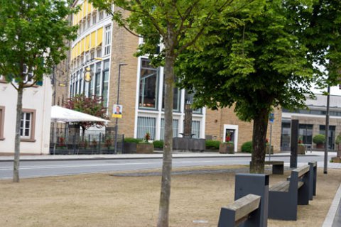 Bild zeigt Platz mit Bänken und Mahnmal von Sebastian Langner im Hintergrund, Am Markt in Bitburg