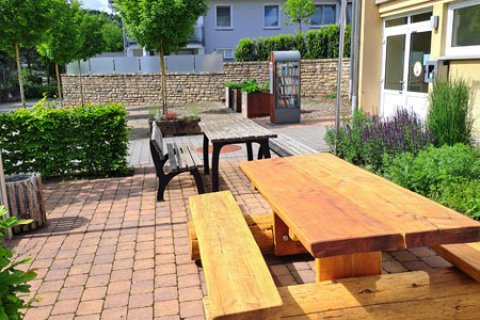 Bild zeigt Vorplatz mit Bänke und Tische vom Bürgerhaus in Bitburg Erdorf